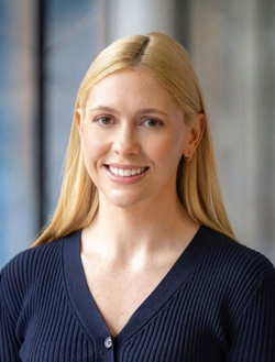 Smiling blonde woman wearing a blue sweater.