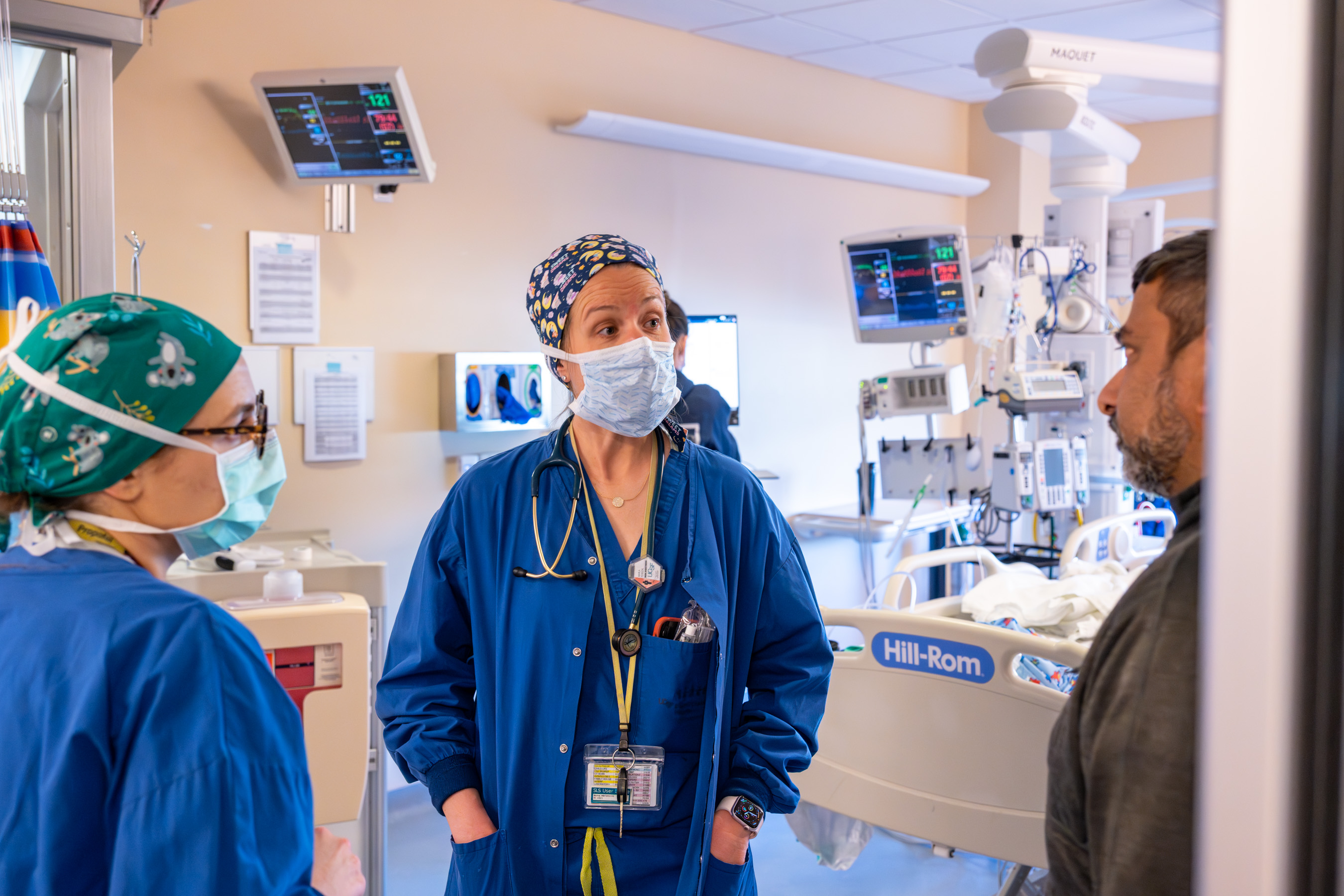 Three doctors standing together to discuss the handoff of a case to the PICU team.