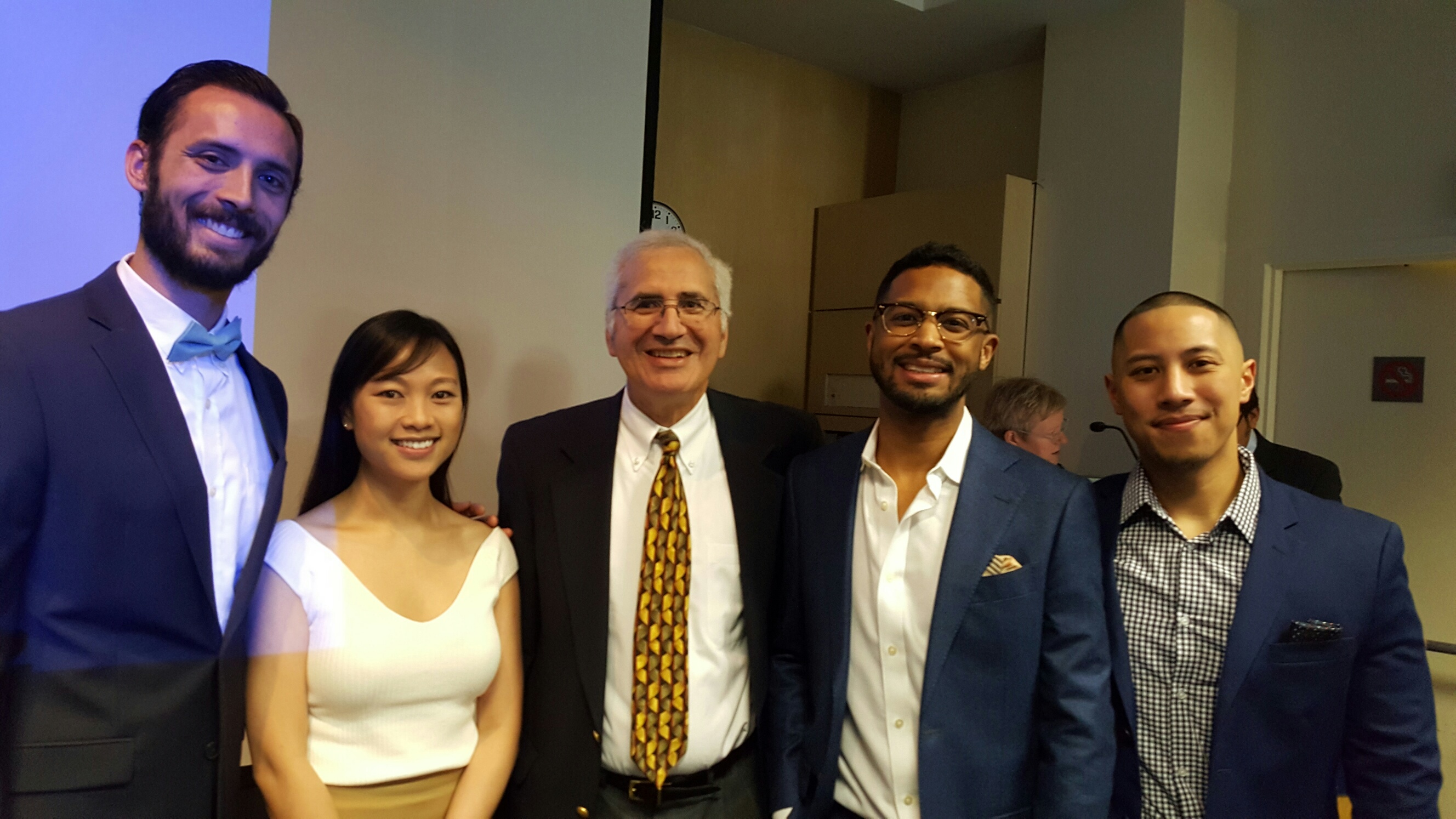 a group shot of people wearing dress clothes at a conference 