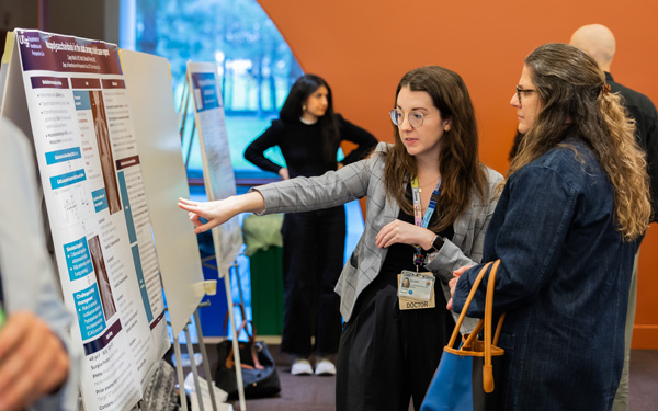 Two women looking at a poster together in a conference setting