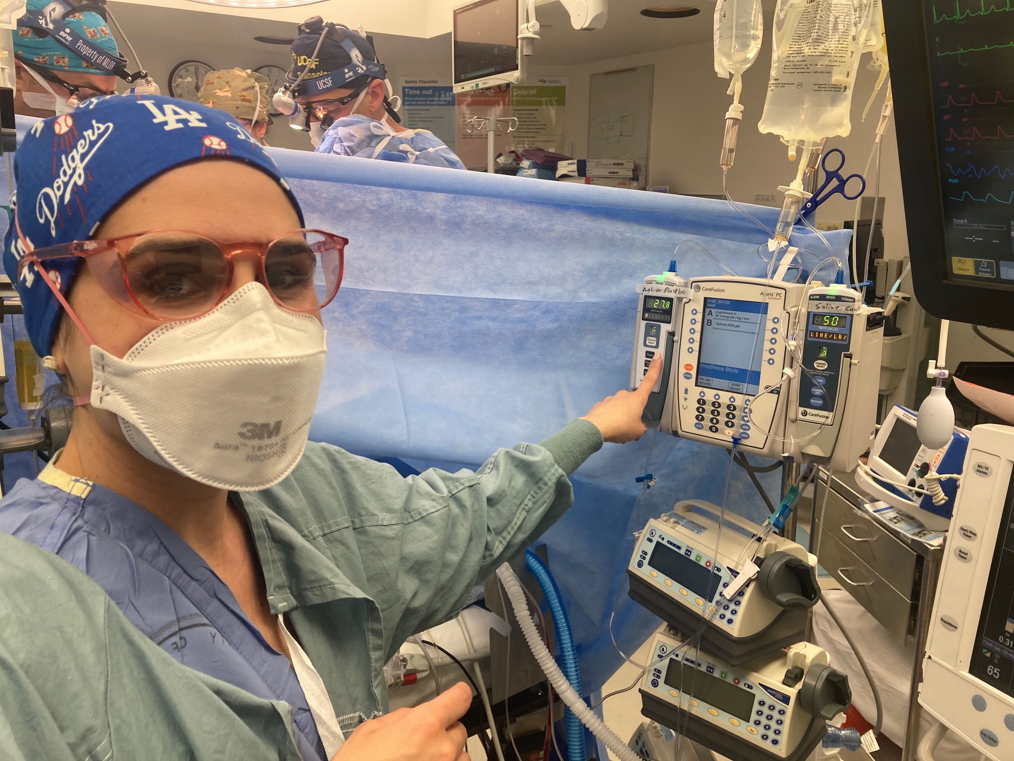 doctor in operating room pointing to machine