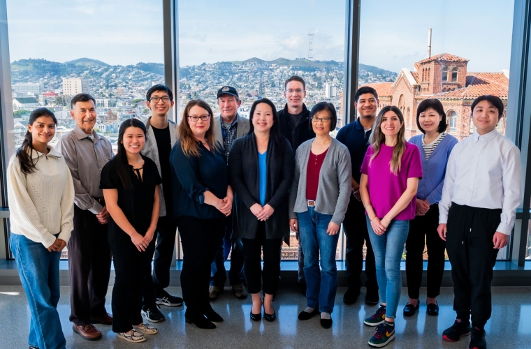 Group of people standing in front of a window, overlooking sf.