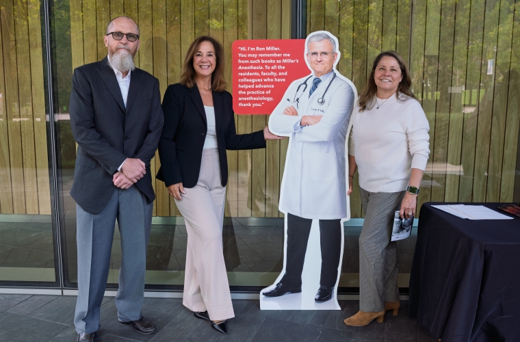 three people standing next to a cardboard cutout