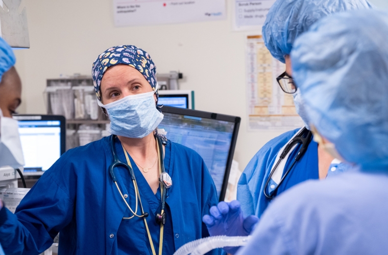 A group of medical professionals wearing scrubs standing together in a clinical setting.
