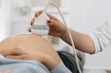 close-up of a pregnant woman lying on her back receiving an ultrasound