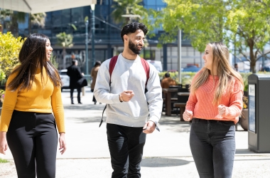 three students walking on campus.