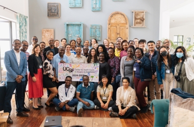 A large group of people posing and smiling together while holding a large sign reading, "UCSF Center for Health Equity in Surgery and Anesthesia 2024-2026."