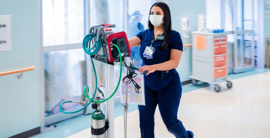 Woman walking with machine in the ICU