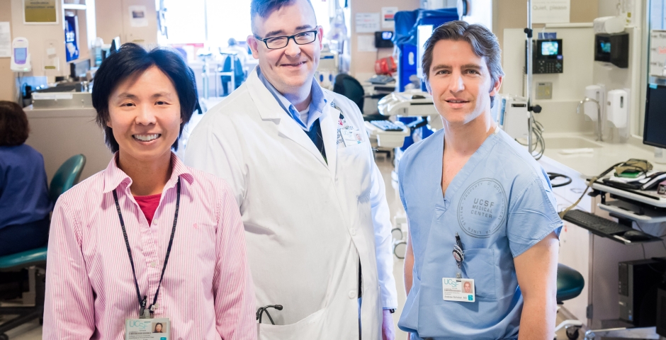 Three people standing together in a clinical space.
