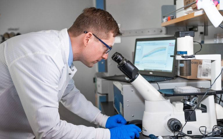 man looking into microscope