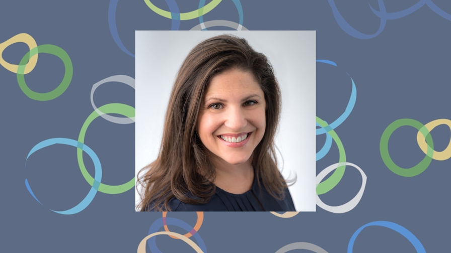 Smiling woman with long dark hair wearing a dark navy top