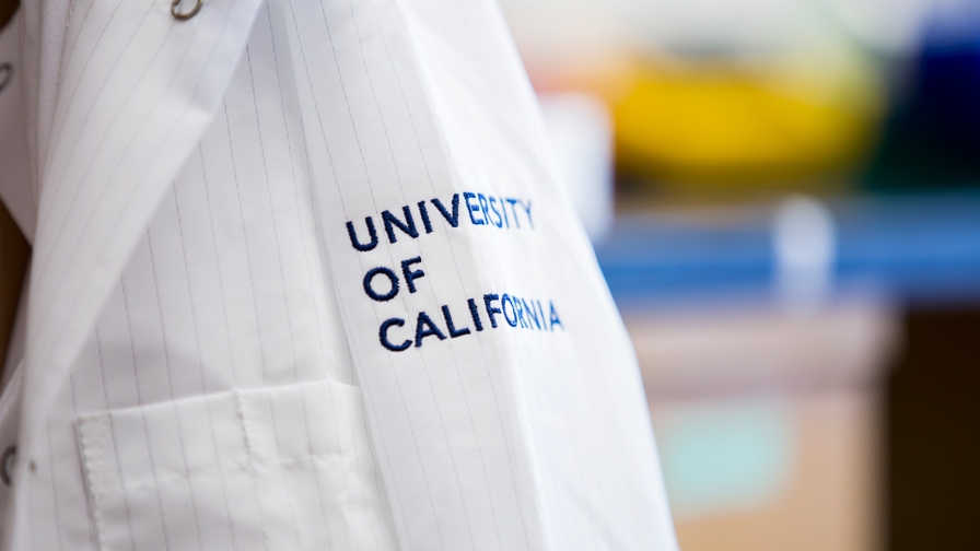 Close up view of lab coat embroidered with "University of California."