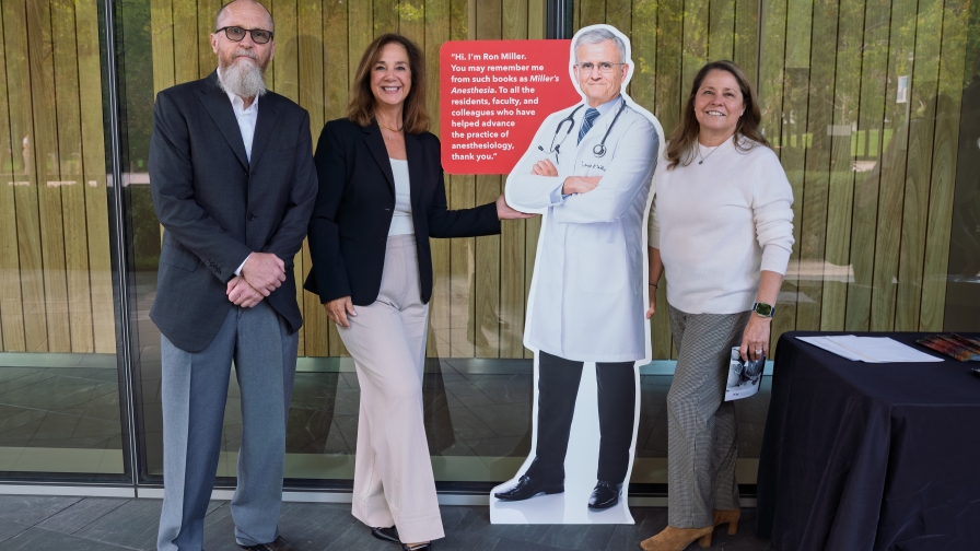 three people standing next to a cardboard cutout