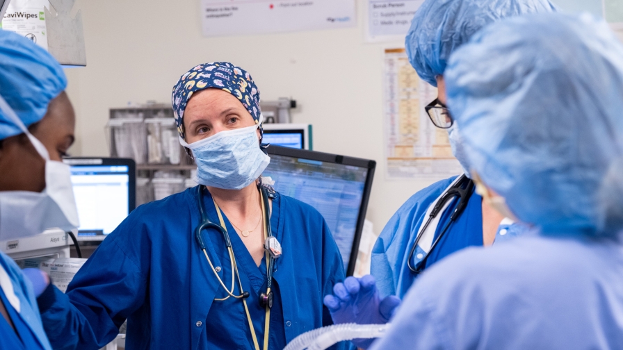 A group of medical professionals wearing scrubs standing together in a clinical setting.