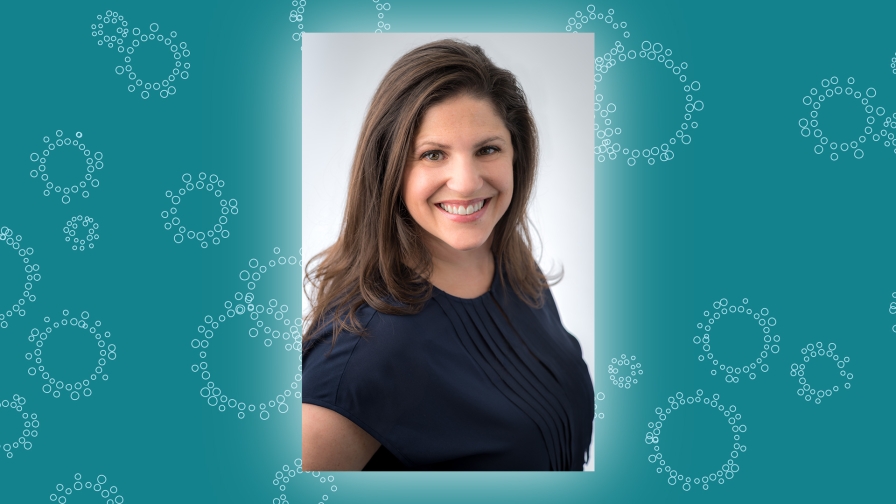 Teal background with white line drawings of circles with a headshot of a smiling person with long wavy brown hair wearing a black shirt.