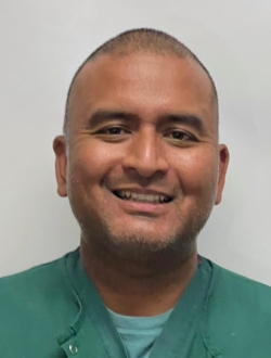 man in green scrubs smiling.