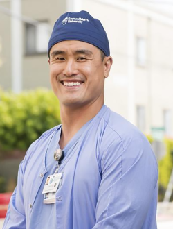 Man in a scrub cap and blue scrubs