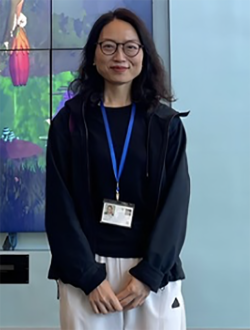 Women wearing a lanyard with name tag smiling at camera