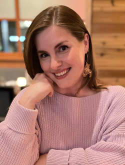 woman smiling in a pink sweater.