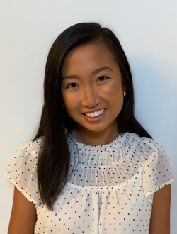 woman in white and black shirt smiling at camera.