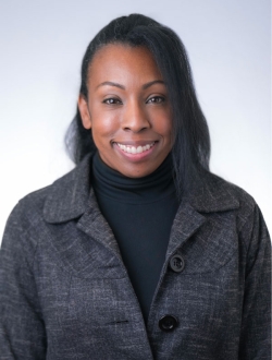 woman in black shirt and dark grey jacket.