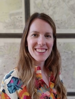 Smiling woman with long light brown hair and a multi-colored shirt