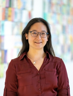 Smiling woman with glasses and long dark with a red shirt