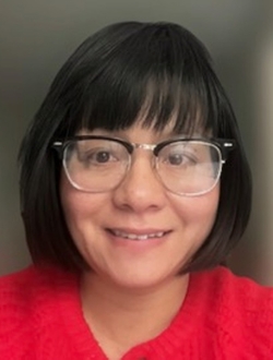 Smiling woman with glasses and shoulder length black hair wearing a red shirt