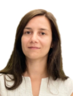 Woman with long brown hair wearing a white top.