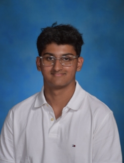 Man with black hair and glasses wearing a white polo shirt with a blue background.
