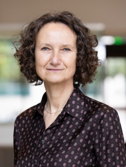 Woman with curly brown hair.