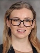 Smiling woman with long blonde hair and glasses.
