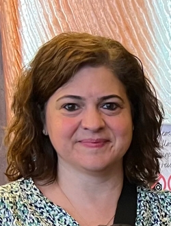 Woman with curly brown hair.