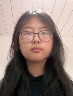 Woman with long dark hair wearing glasses and a black top.