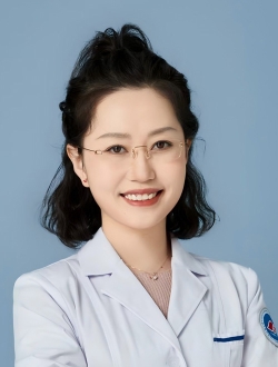 Woman with shoulder length black hair wearing wire rimmed glasses and a white lab coat.