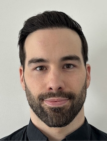 Man with short black hair and beard, wearing a black shirt.