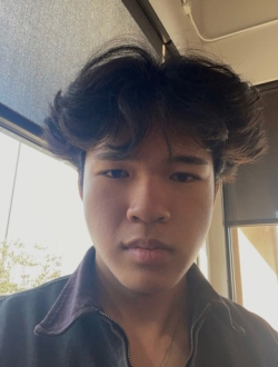 Man with medium long black hair wearing a zippered sweater.