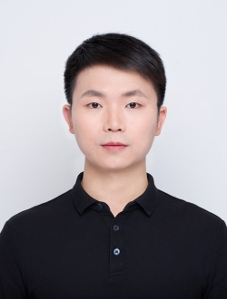 Man with short black hear wearing a black polo shirt.