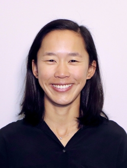 Smiling woman with long straight black hair wearing a black shirt.