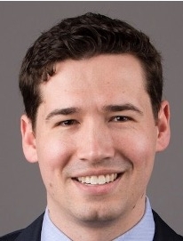 Smiling man with short dark hair.