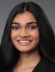 Smiling woman with long black hair wearing a black jacket.