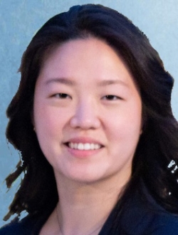 Smiling person with long wavy black hair.