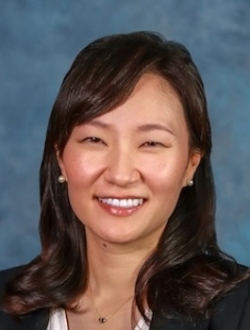 Smiling person with long dark brown hair.