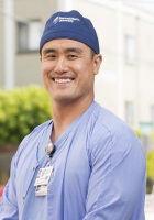 Man in a scrub cap and blue scrubs
