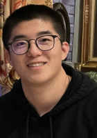 Man with glasses wearing black shirt smiling at camera