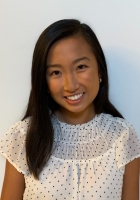 woman in white and black shirt smiling at camera.