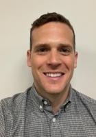 Smiling man with short dark hair and a grey shirt