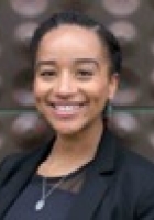 Smiling woman with black hair pulled back, wearing a black blazer.