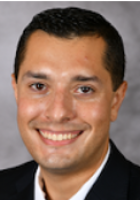 Smiling man with short black hair.