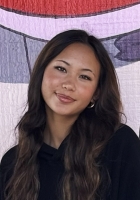 Woman with long wavy dark brown hair wearing a black sweater.